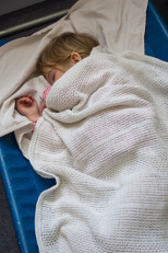 Child resting in a camp bed